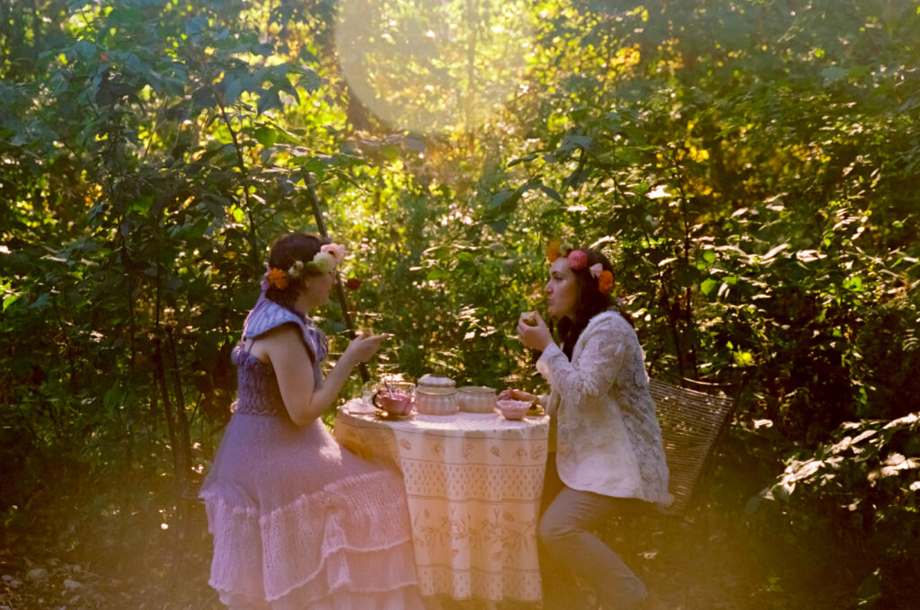 A couple shares tea and sandwiches  in the forest after their wedding ceremony