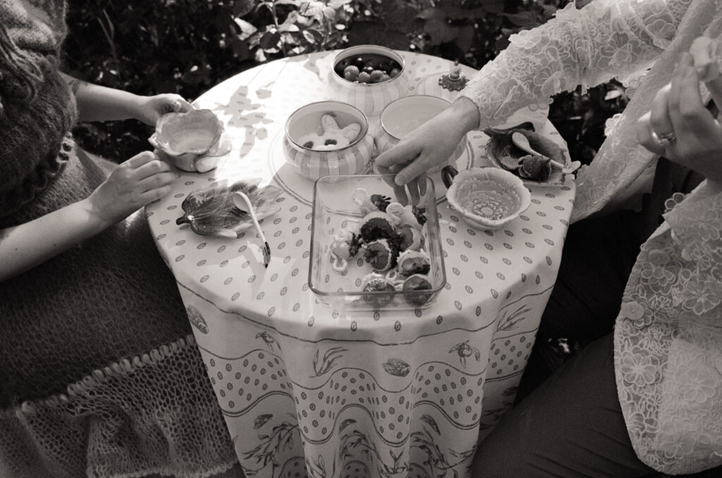 Black and white detail photograph of wedding day table spread, complete with chocolate covered strawberries and jam-filled cookies. 