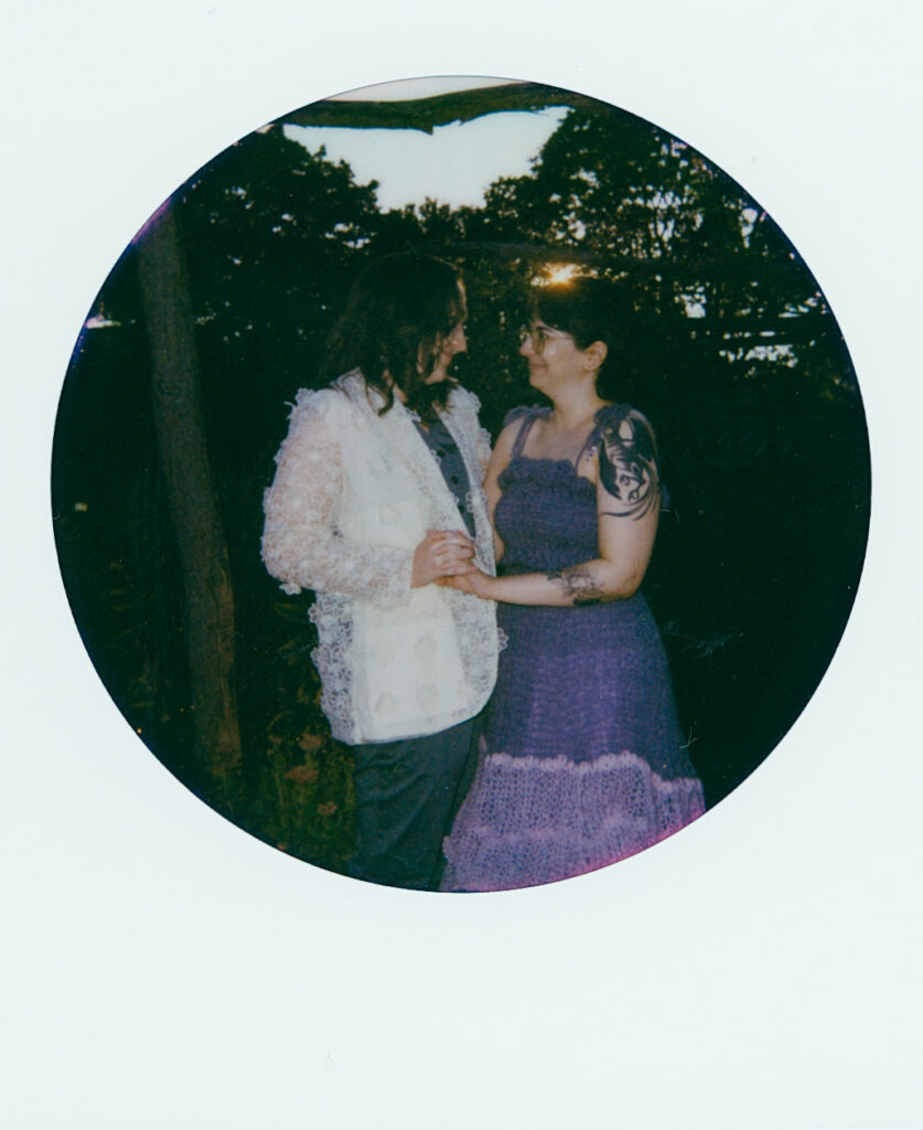 Polaroid photograph of couple looking lovingly at one another amongst the setting sun.