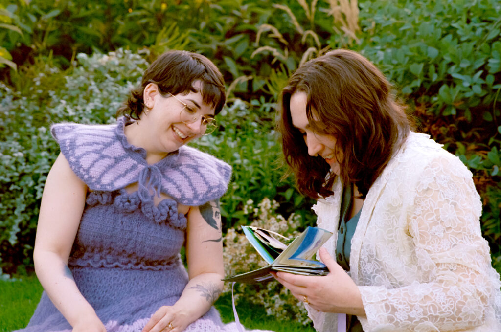 Newlyweds look through a carousel book together, sitting side by side. 