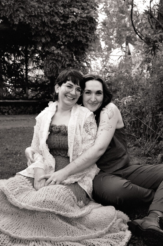 Black and white smiling portrait of newlyweds at Smith College's gardens. 