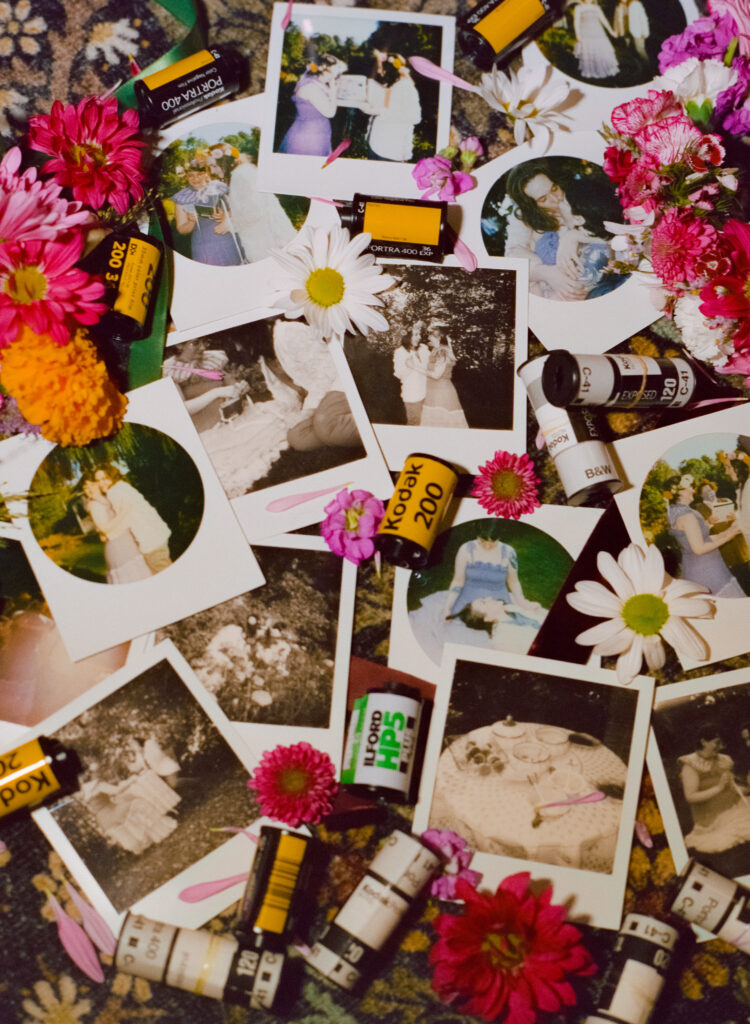 Flatlay of polaroids, flowers, and 35mm and 120 film canisters showcasing a couple's full wedding day, laid over a background of floral carpet. 