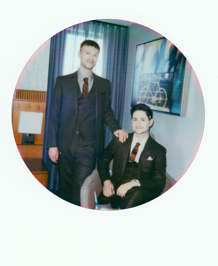 polaroid photo of queer couple with a hand one one shoulder