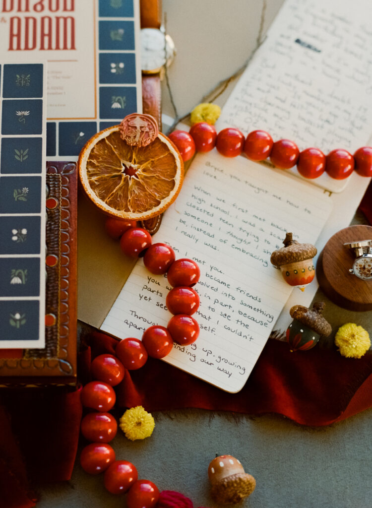dried oranges, wedding vow books, and wedding invitations in a flat lay detail shot