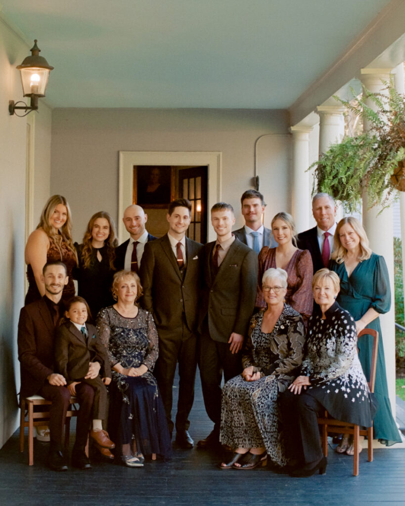 Queer couple and family posing for a group photo at The Lyman Estate