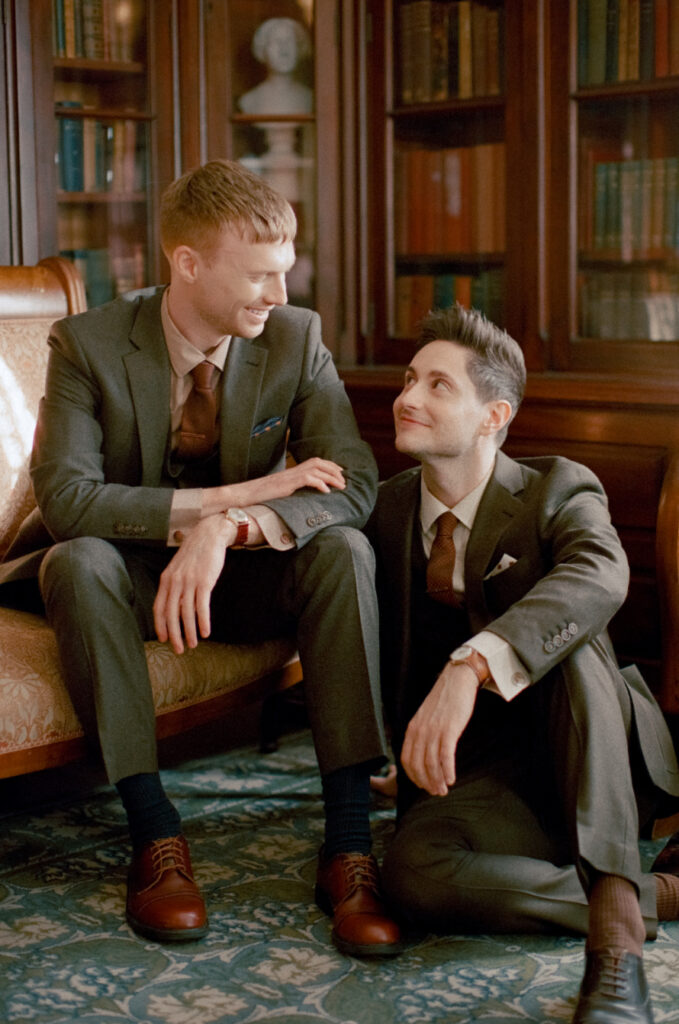 queer couple staring lovingly at one another in the library at The Lyman Estate on their wedding day