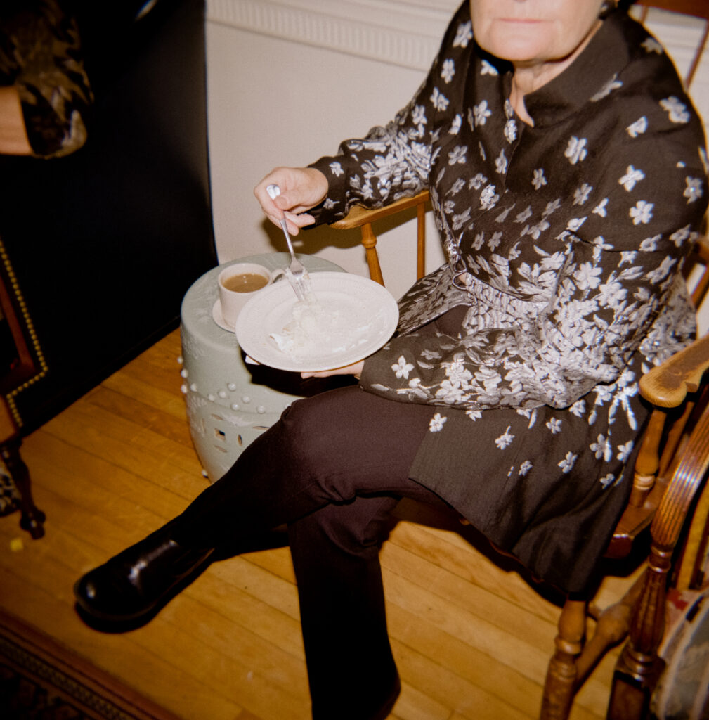 women holding a plate of wedding cake with a cup of coffee