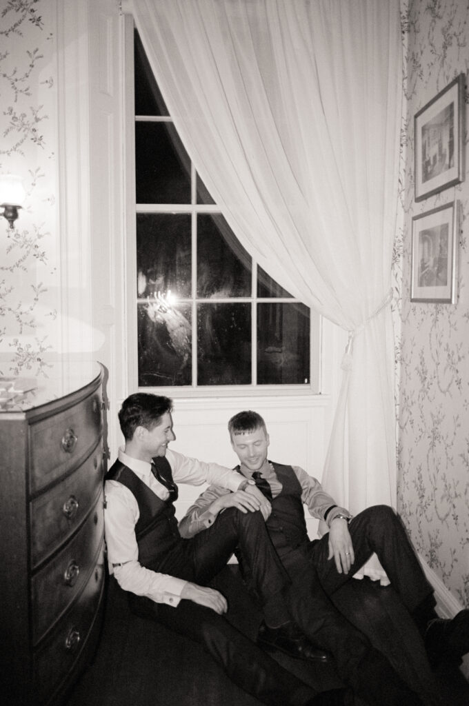 queer grooms sitting on the floor talking and laughing at the Lyman Estate