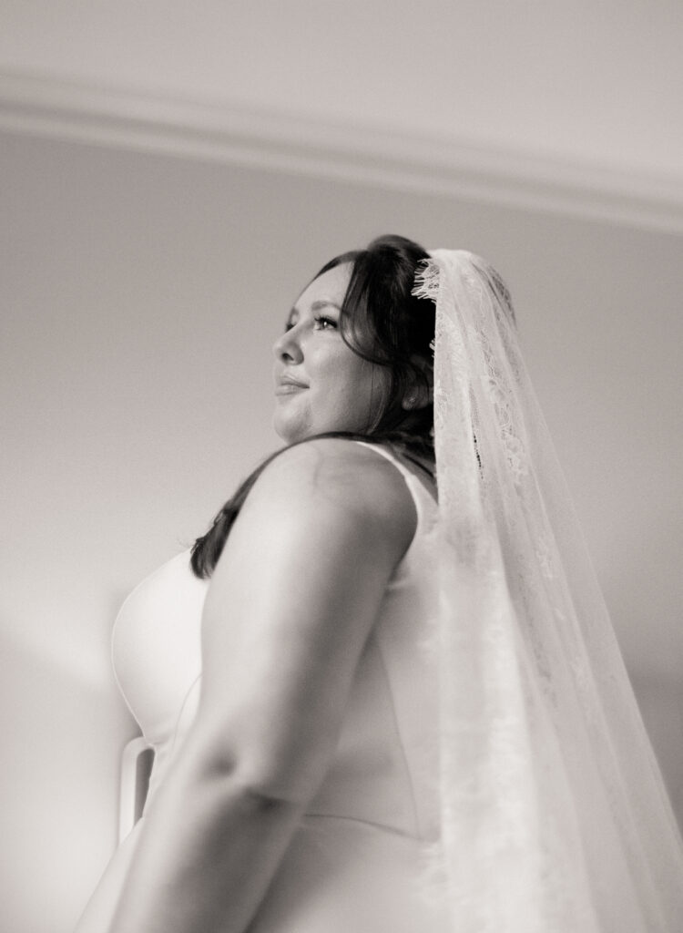black and white film photo of bride posing in her wedding dress