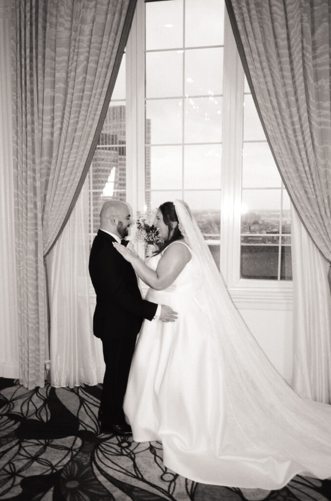 bride and groom smiling and laughing at each other in black in white photo