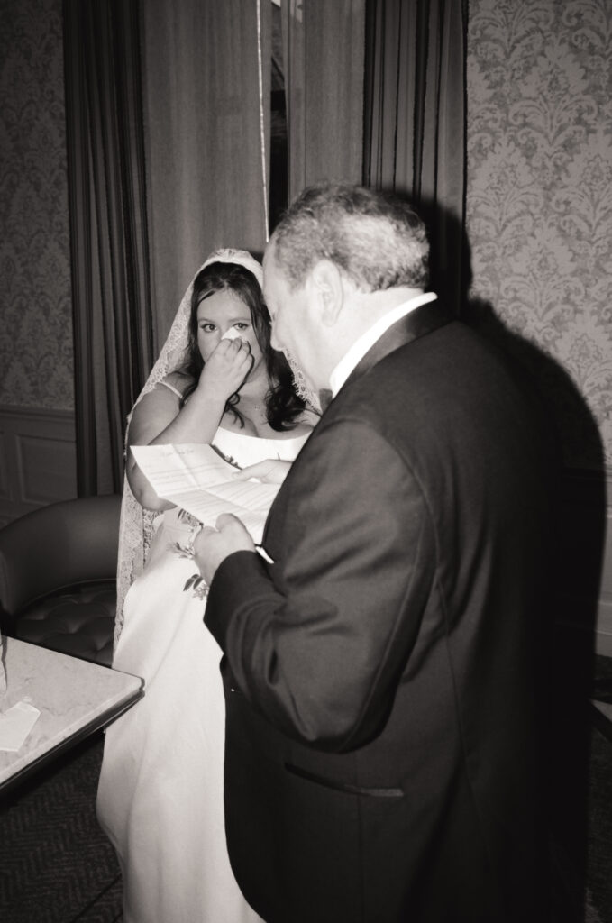 bride crying as her dad reads a letter from her before walking down the aisle