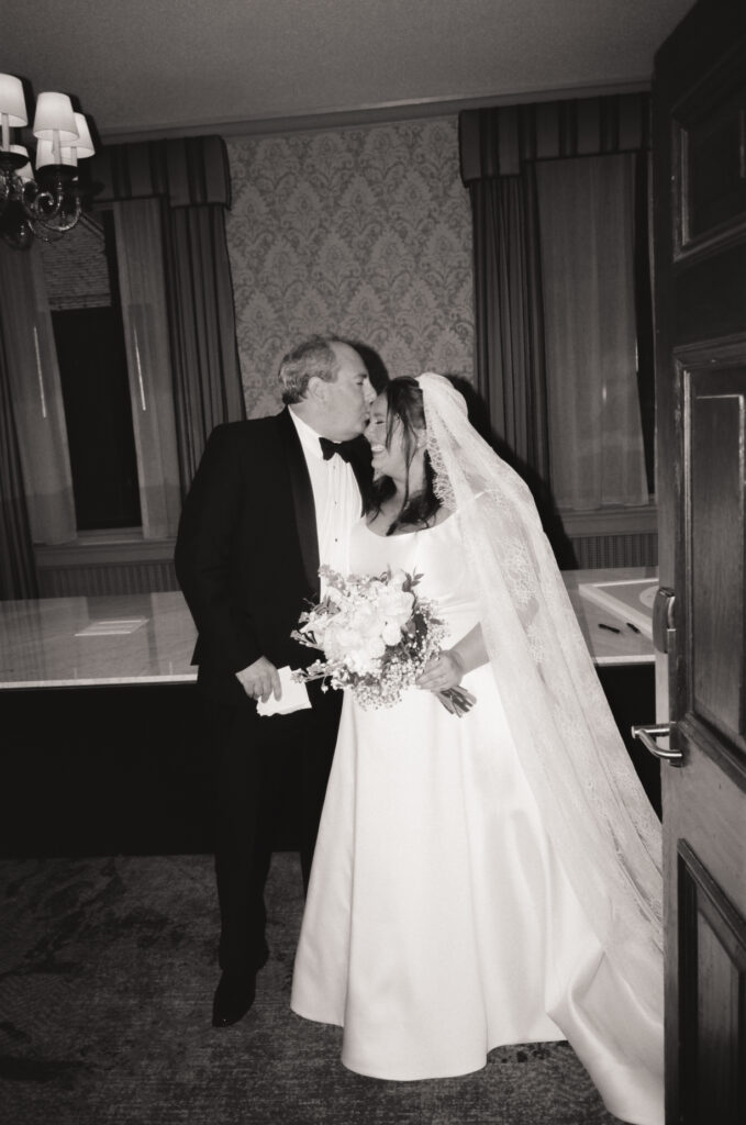 father kissing bride on the forehead walking down the aisle