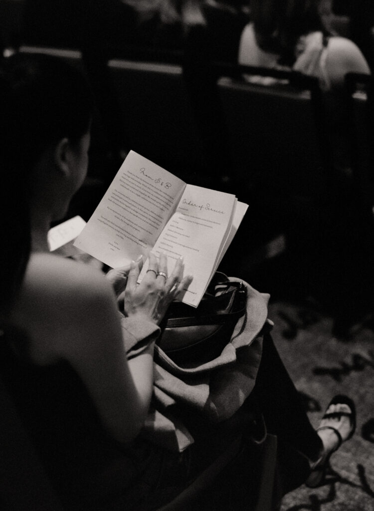 black and white photo of wedding guest holding programs
