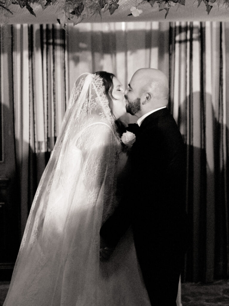 bride and groom kissing during jewish wedding ceremony