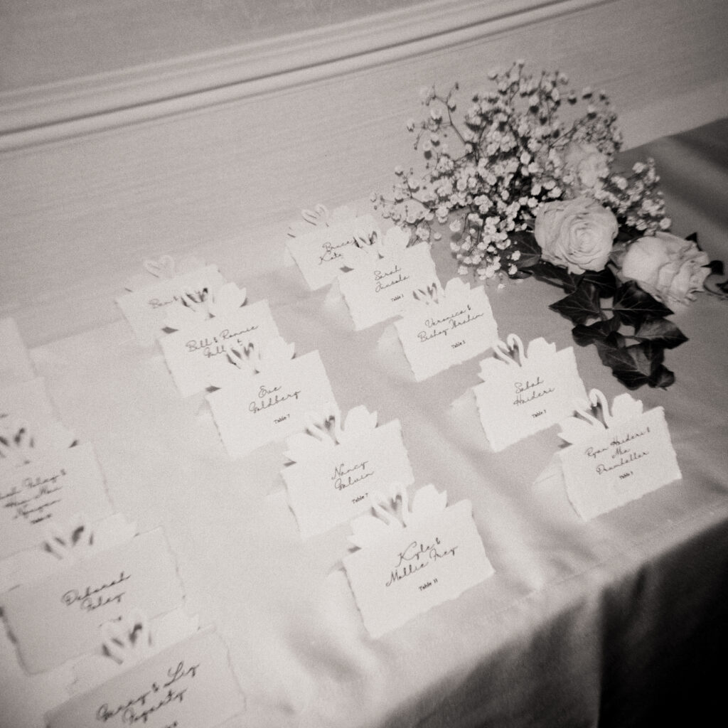 wedding place cards and white flower arrangements