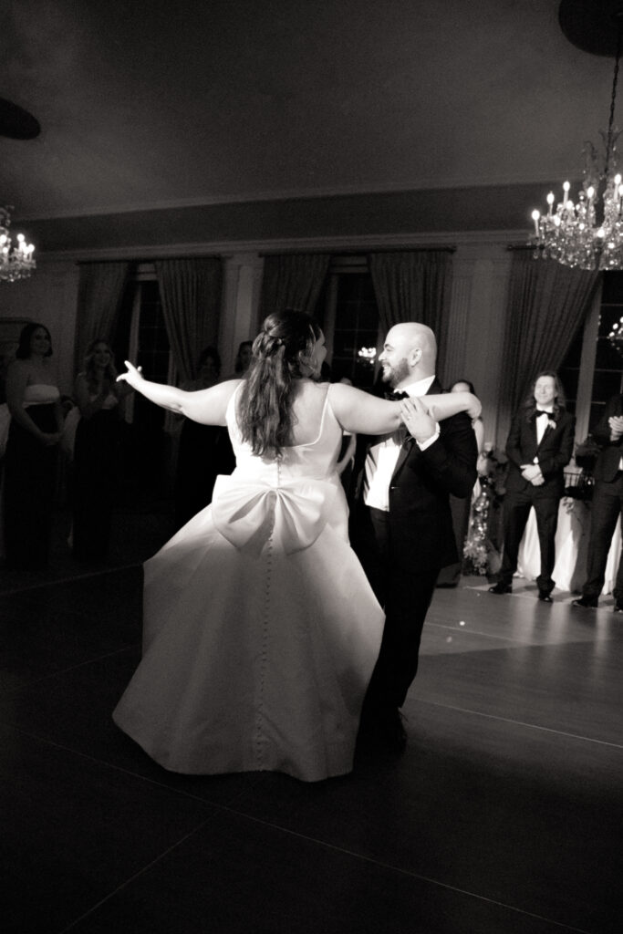 black and white photo of bride and groom dancing