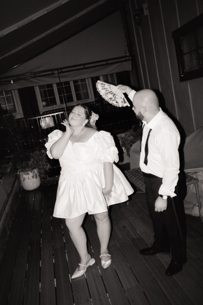 groom fanning bride in black and white photo