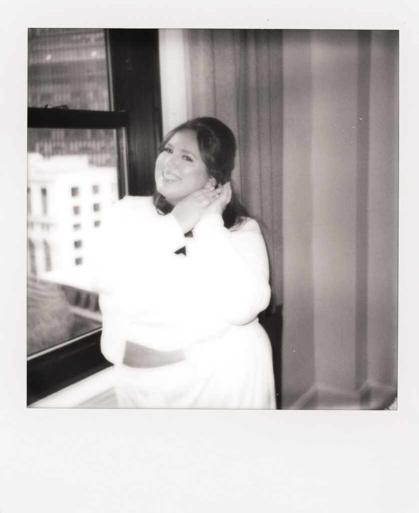 polaroid photo of bride putting her earrings on while getting ready