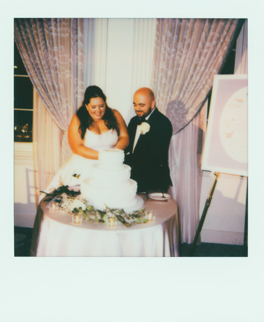 polaroid photo of bride and groom cutting wedding cake
