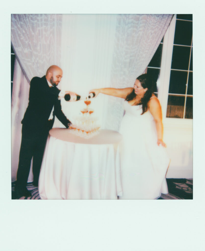 polaroid photo of bride and groom pouring champagne