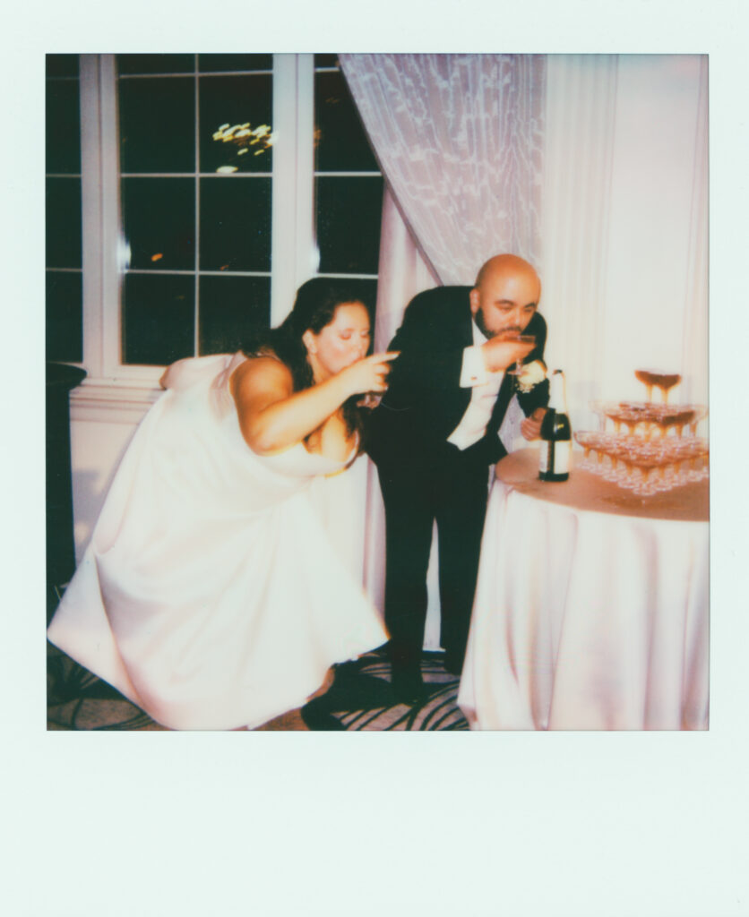 polaroid photo of bride and groom drinking champagne