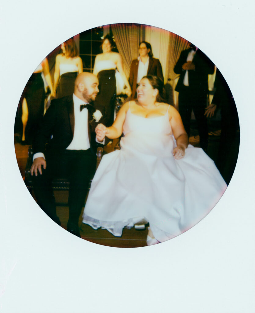 polaroid of bride and groom holding hands and smiling