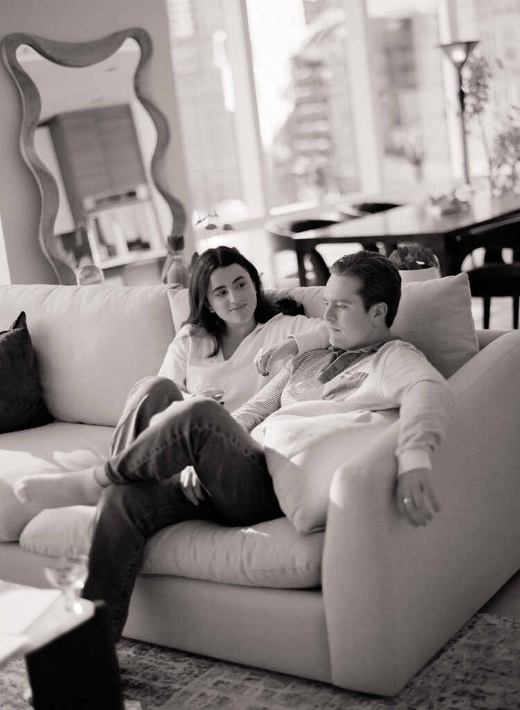 a man and woman sitting on a couch at a engagement shoot on film 