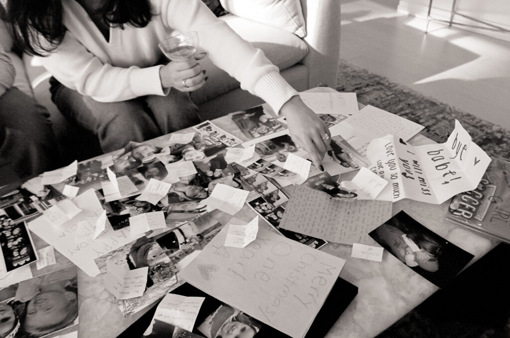 a woman sitting on a couch with a table full of pictures at a engagement shoot on film 
