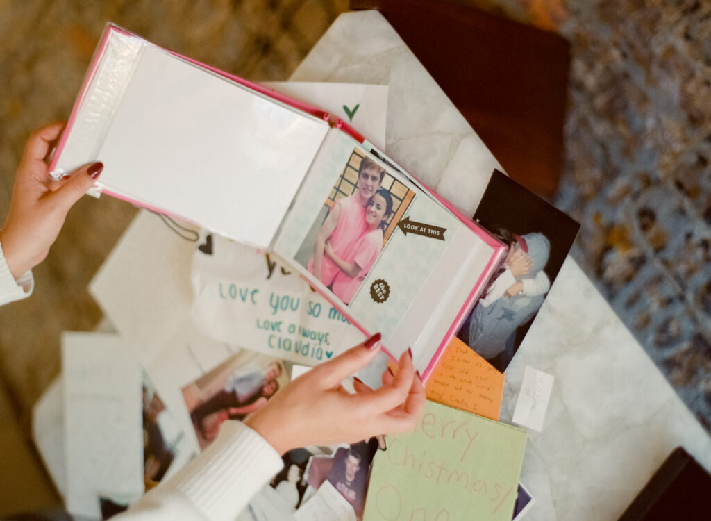 a hand holding a photo album at a engagement shoot on film 