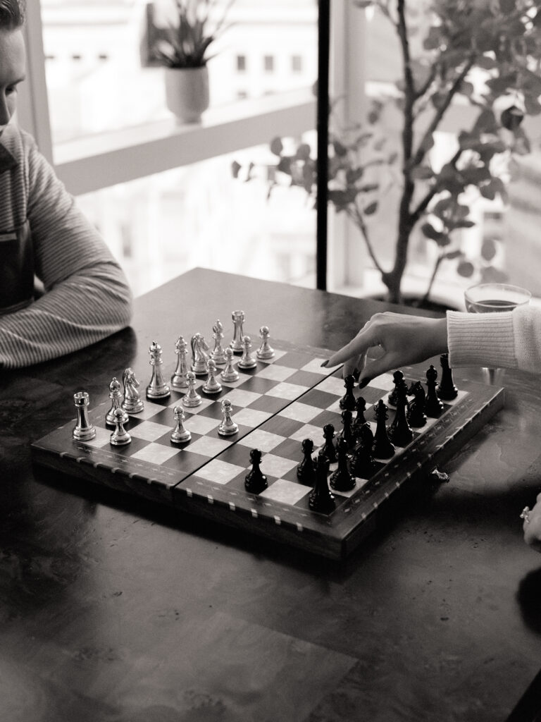 a person playing chess with a hand at a engagement shoot on film 