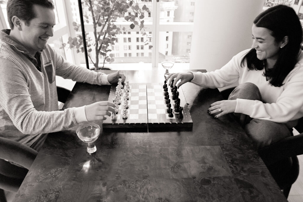 couple playing chess in their apartment during film engagement photos 