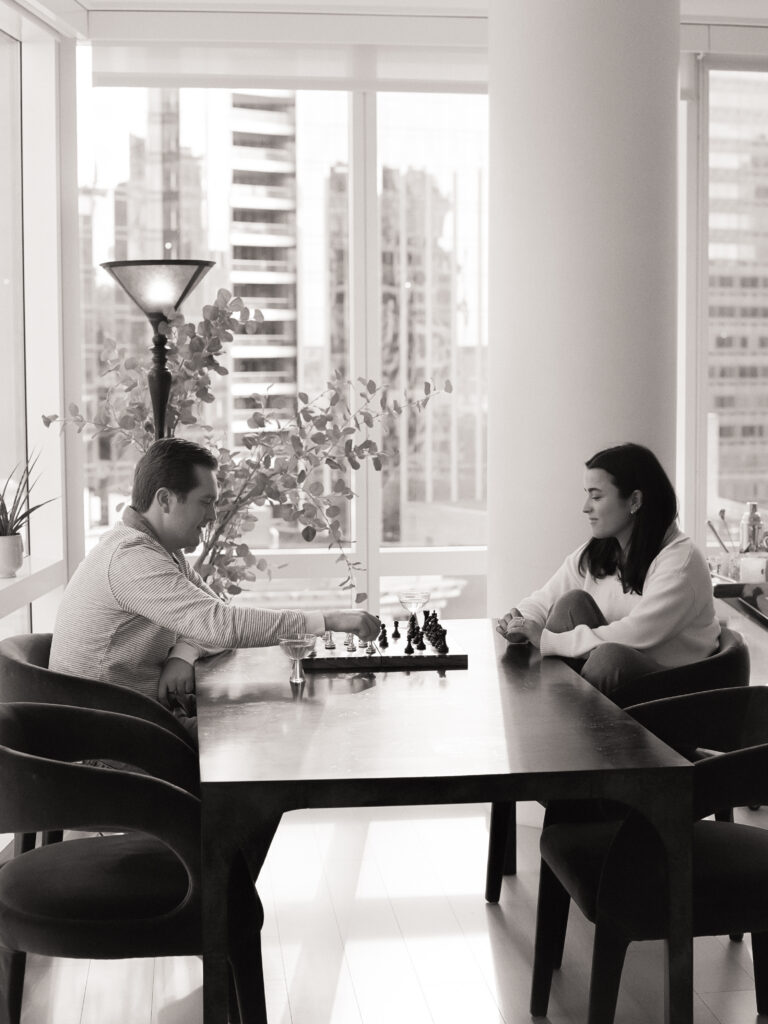 couple playing chess in their apartment during film engagement photos 