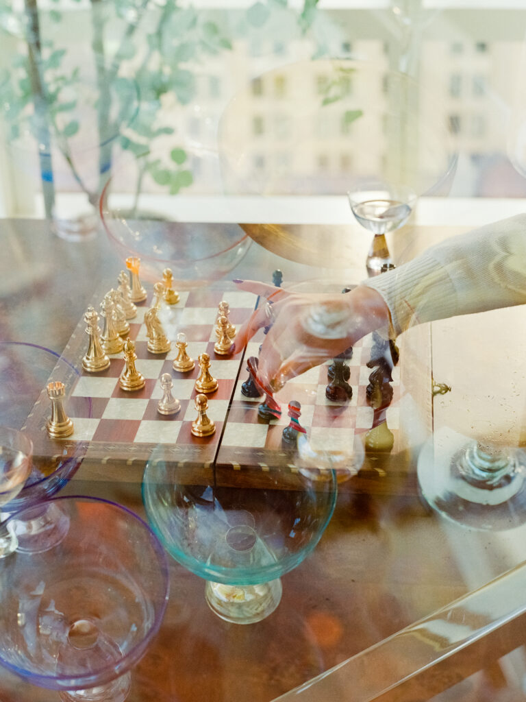 couple playing chess in their apartment during film engagement photos 