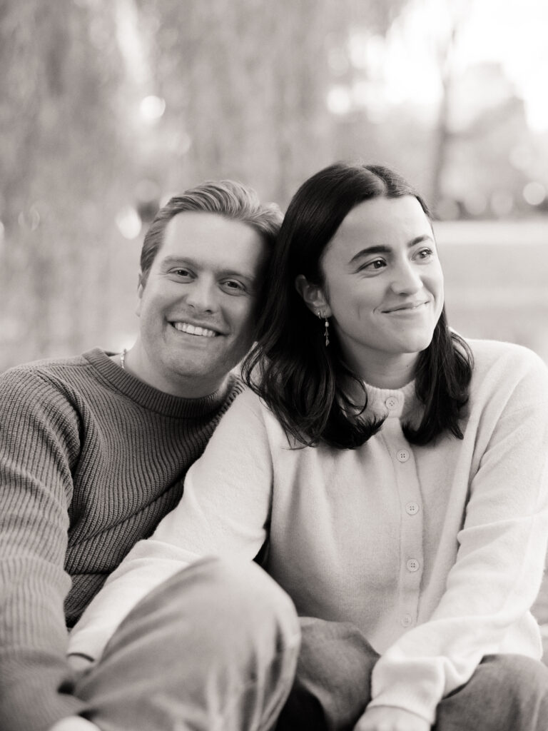 couple smiling under a tree during film engagement photos 