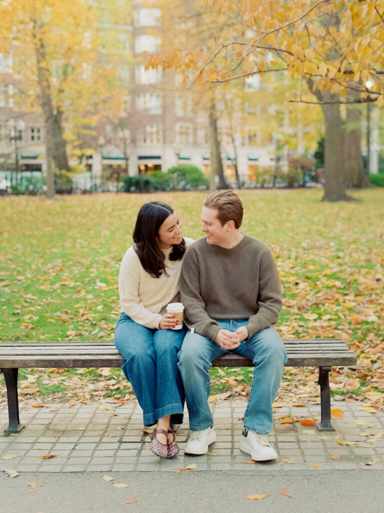 couple smiling under a tree during film engagement photos 