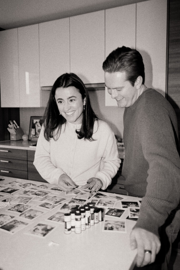a man and woman looking at pictures at a engagement shoot on film 