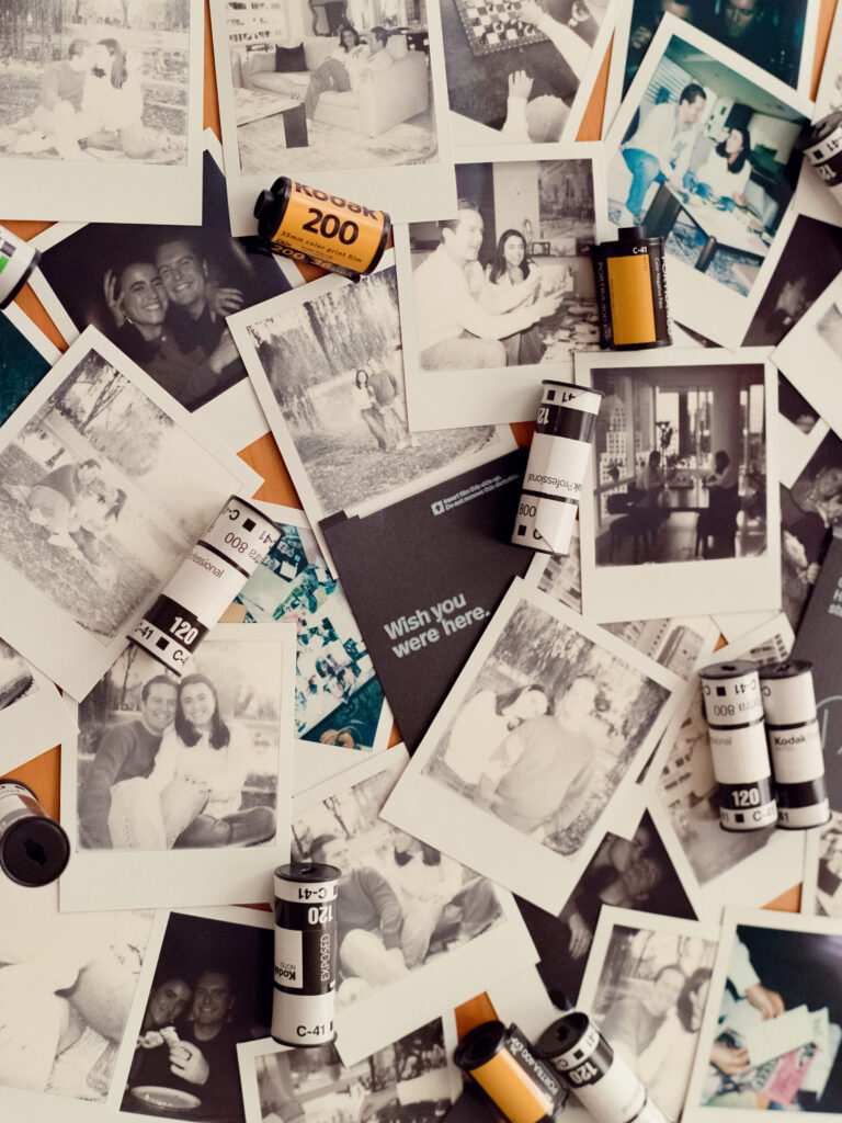 polaroid photos and film rolls scattered on table 
