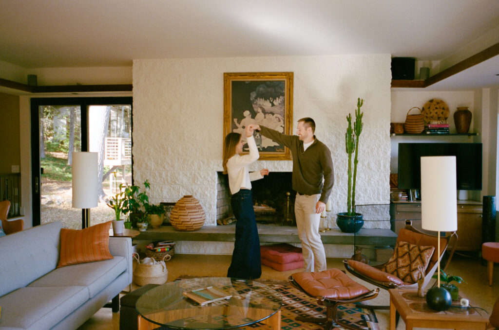 couple dancing in front of fireplace during film engagement shoot
