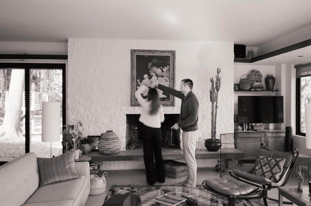 couple dancing in front of fireplace during film engagement shoot