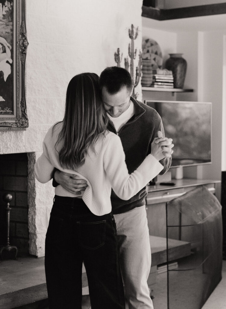 couple dancing in front of fireplace during film engagement shoot