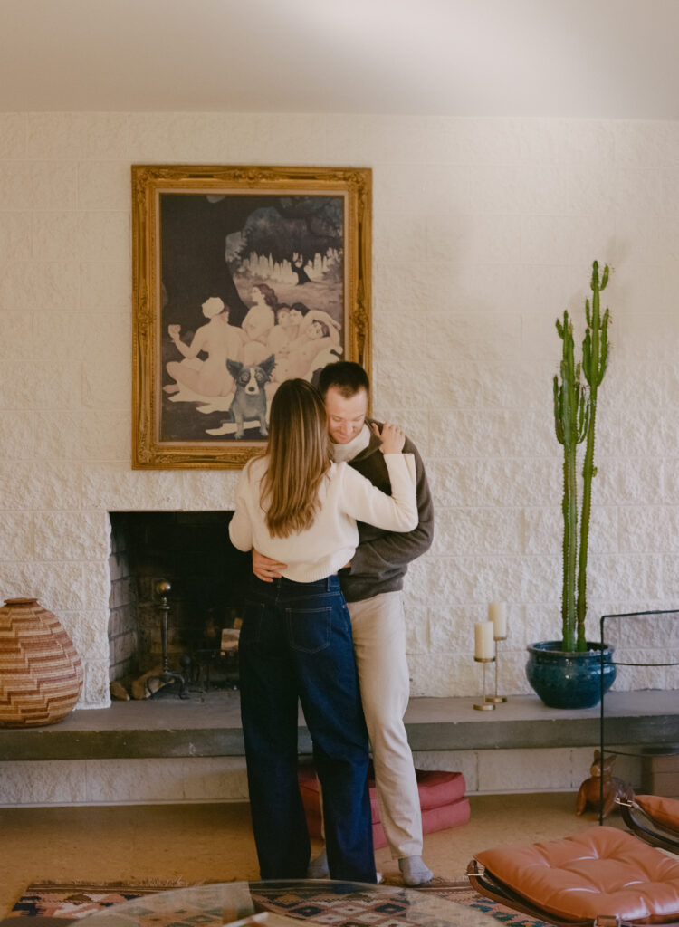 couple dancing in front of fireplace during film engagement shoot