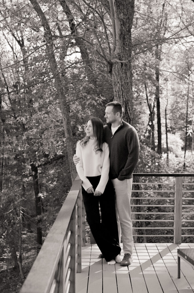 couple looking out on a balcony with coffee during film engagement photos