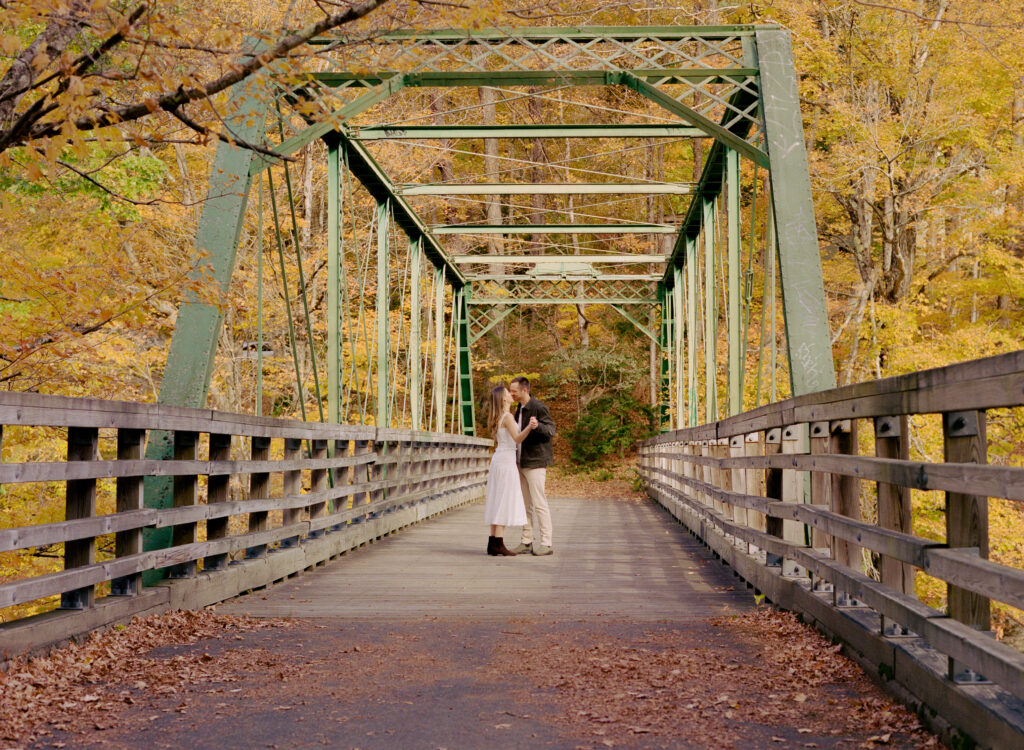 couple kissing on bridge during fall 