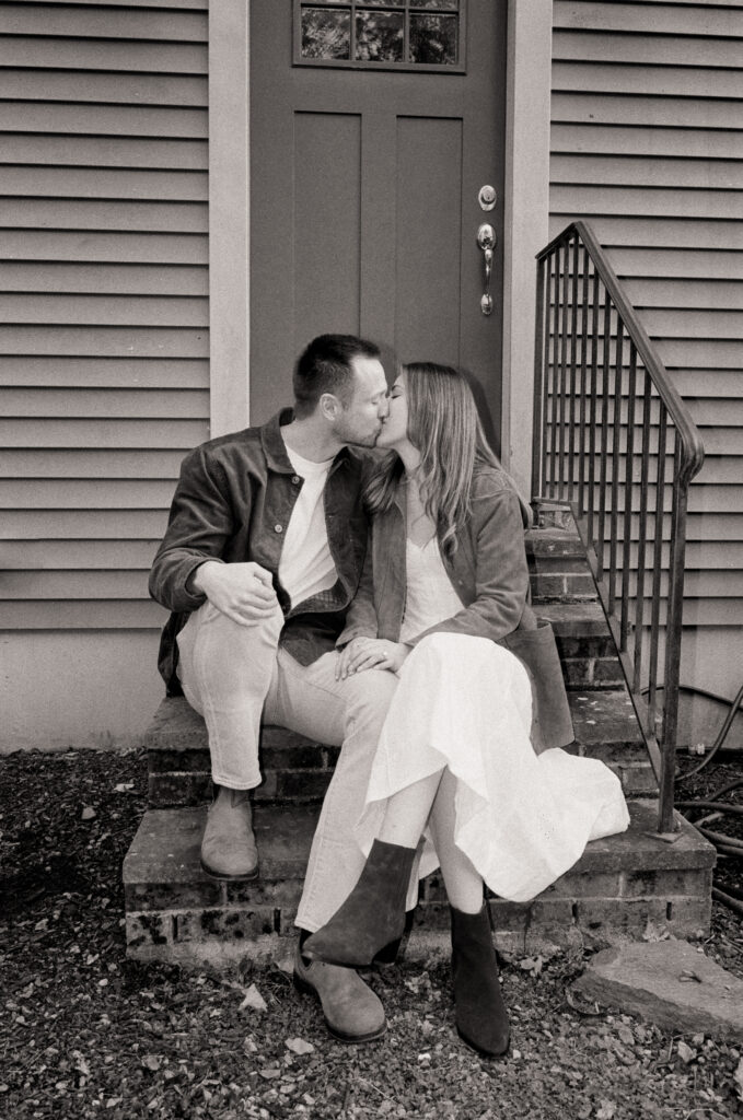 couple kissing on porch stoop 