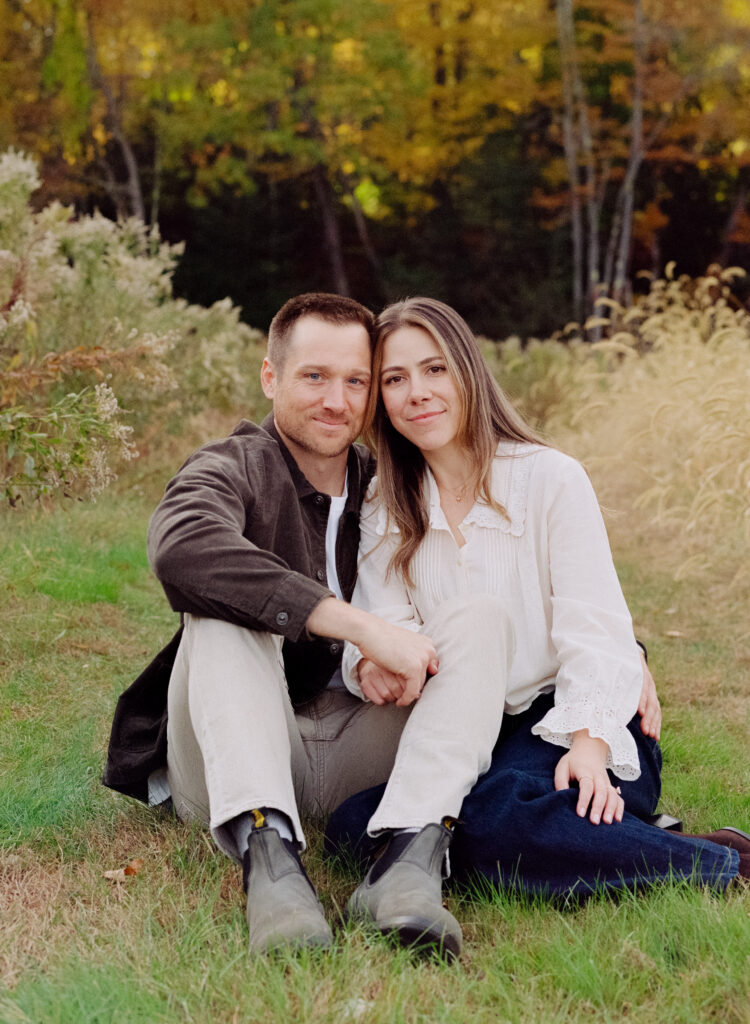 couple snuggling in a field during film engagement photos 