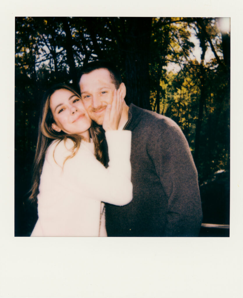 polaroid photo of couple squeezing faces together and smiling during film engagement photos 