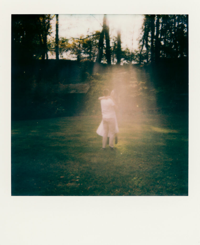 polaroid photo of couple kissing in woods 