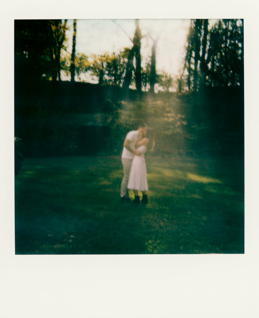 polaroid photo of couple kissing in woods 