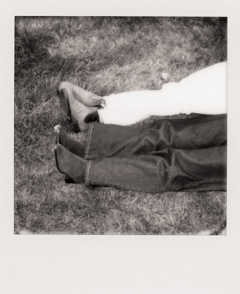 polaroid photo of couple snuggling in a field during film engagement photos 