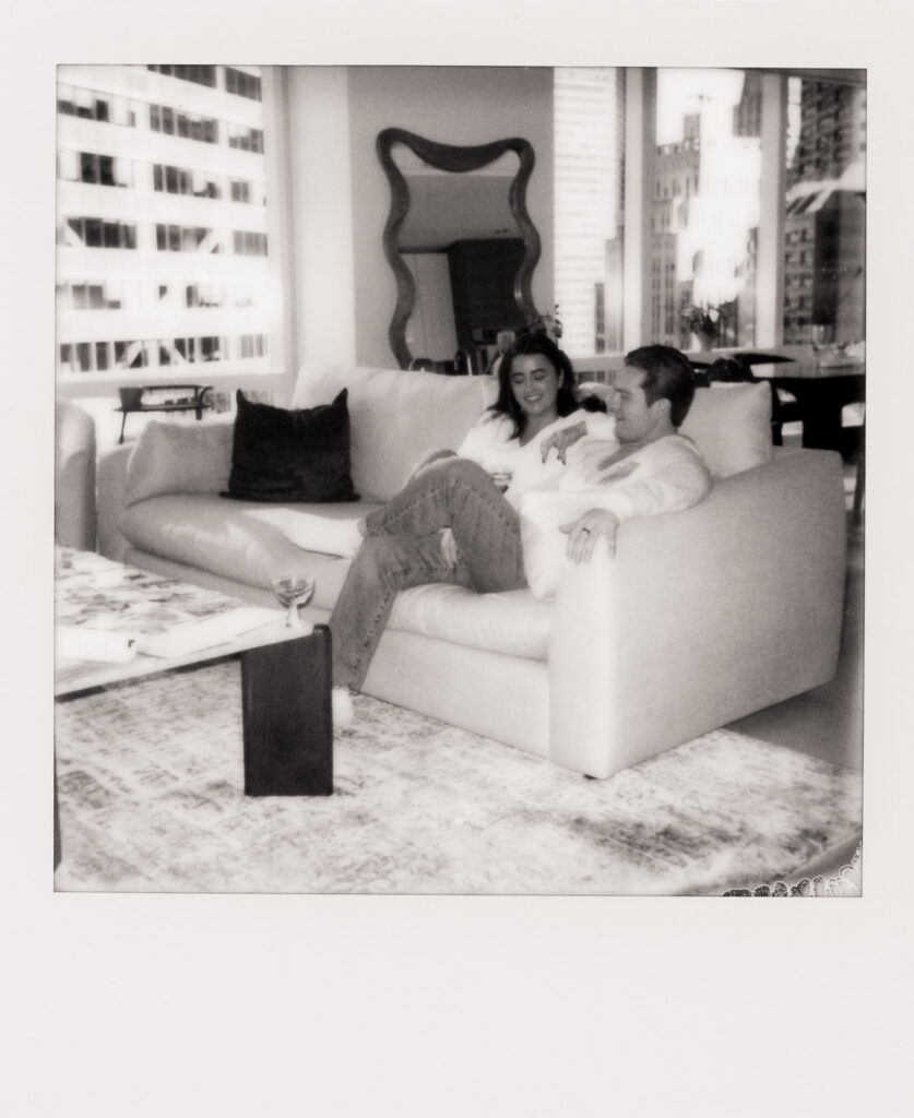 a man and woman sitting on a couch at a engagement shoot on film 